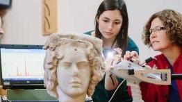 澳门金沙线上赌博官网 professor 和 her student examine an ancient sculpted bust.